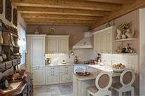 Cucina in legno laccato - scala in pietra- travi a vista